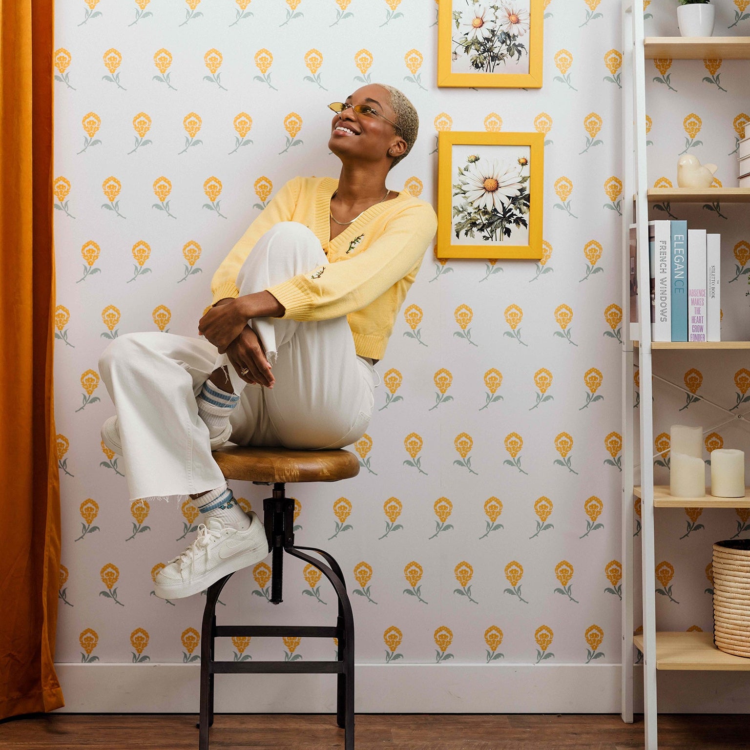 Dancing Iris wallpaper in yellow styled in a floral interior with a happy woman and curtains - Huggleberry Hill