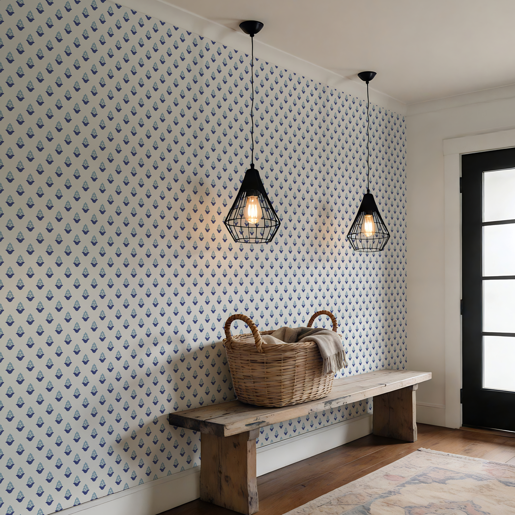 Blue and navy floral repeat wallpaper in a light entryway with rustic wooden bench, woven basket, and black pendant lighting