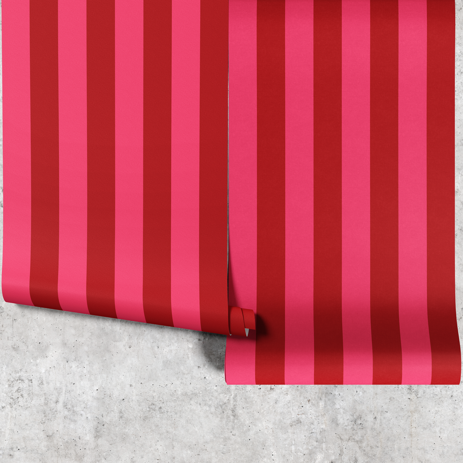 Two panels of red and pink striped wallpaper hanging against a concrete wall
