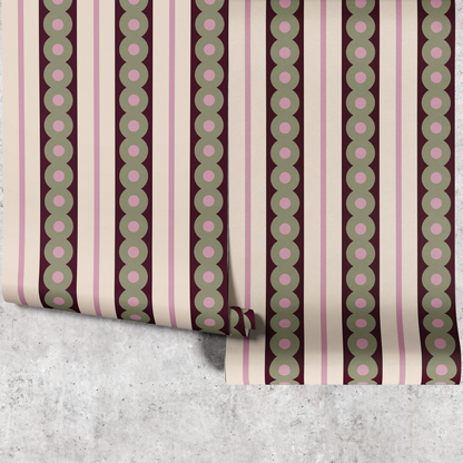 Two panels of green circles wide stripe wallpaper hanging against a concrete wall
