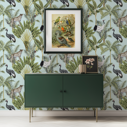 A modern hallway with a green sideboard accented by gold accessories against a wall with light blue Rainforest Animal wallpaper