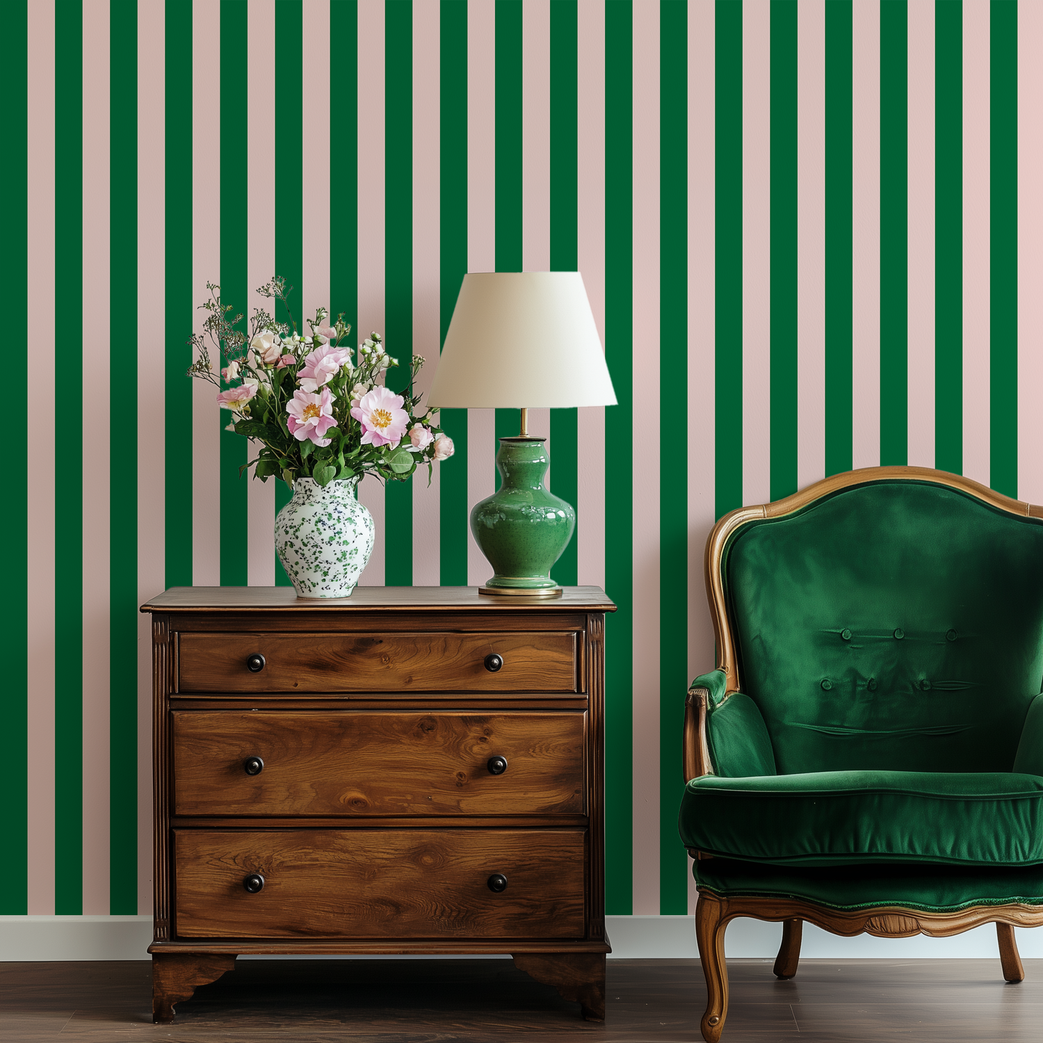 An antique dresser and green velvet chair with pink and green striped wallpaper behind it