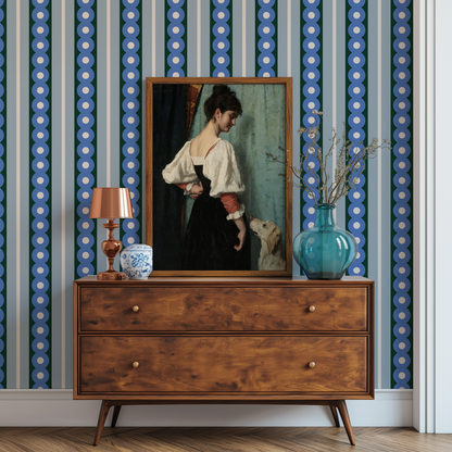 A midcentury console table against a wall with a midcentury wide stripe wallpaper in blue and green