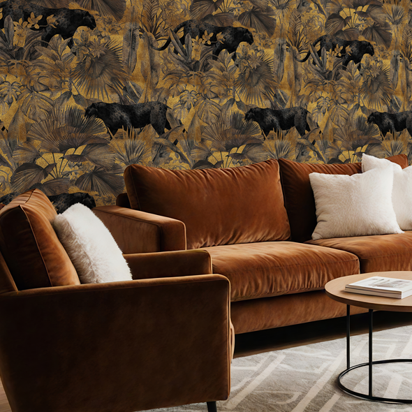Gold jungle panther wallpaper with layered foliage in a warm-toned living room with a brown velvet sofa and natural textures
