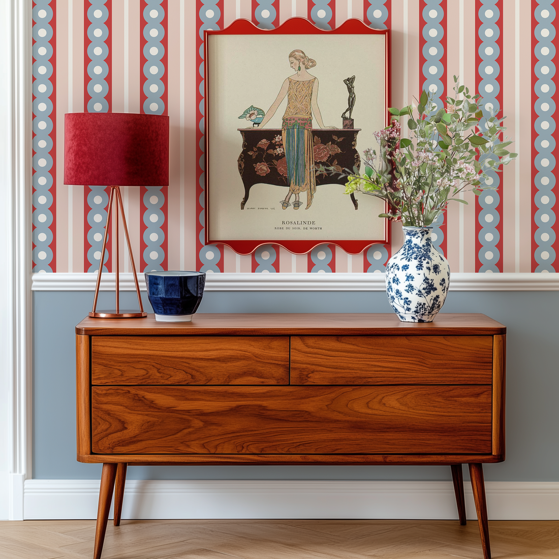 A midcentury sideboard in front of a wall with wide stripe wallpaper in gray, red and pink