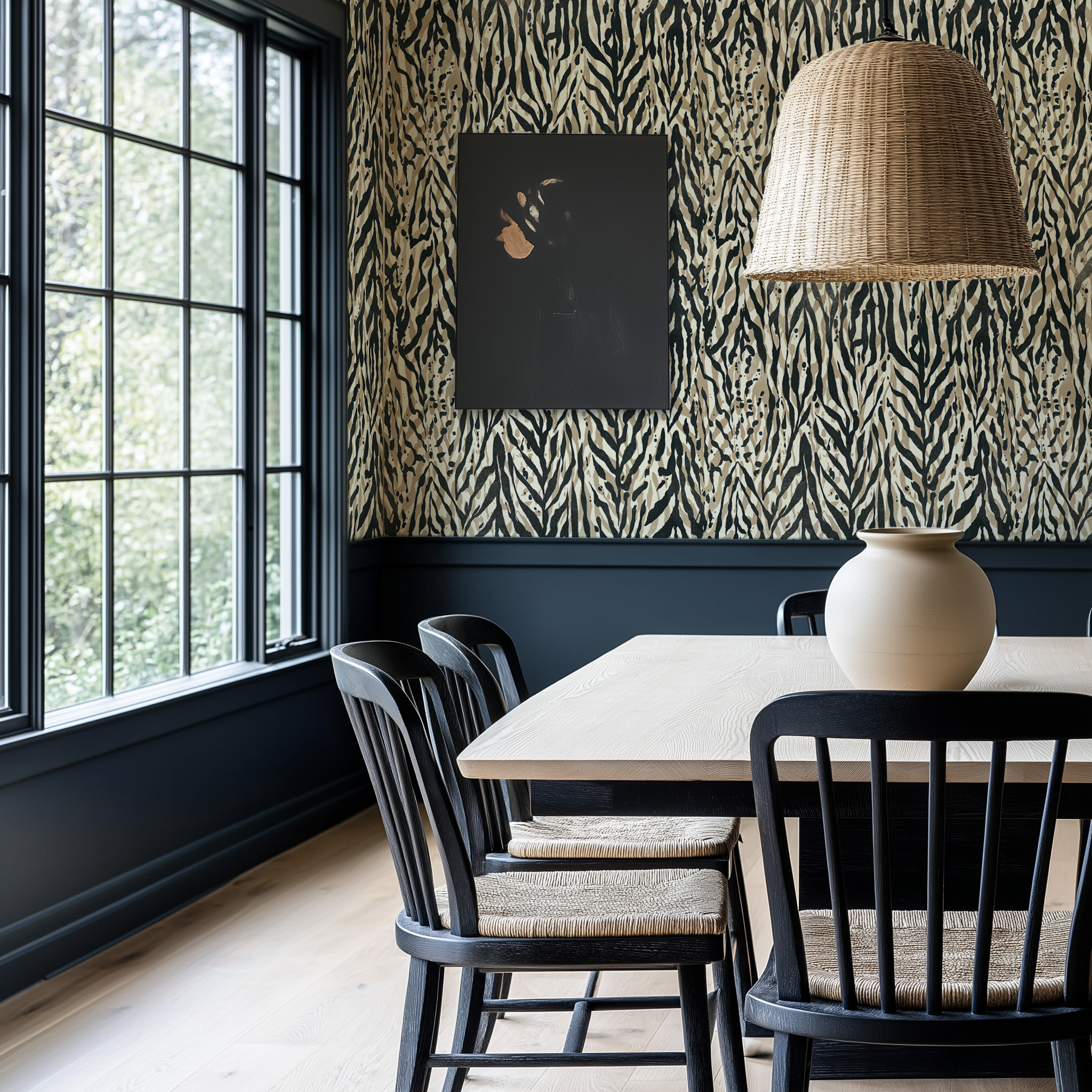 A beautiful modern farmhouse dining room with dark gray wainscotting and abstract zebra print wallpaper. 