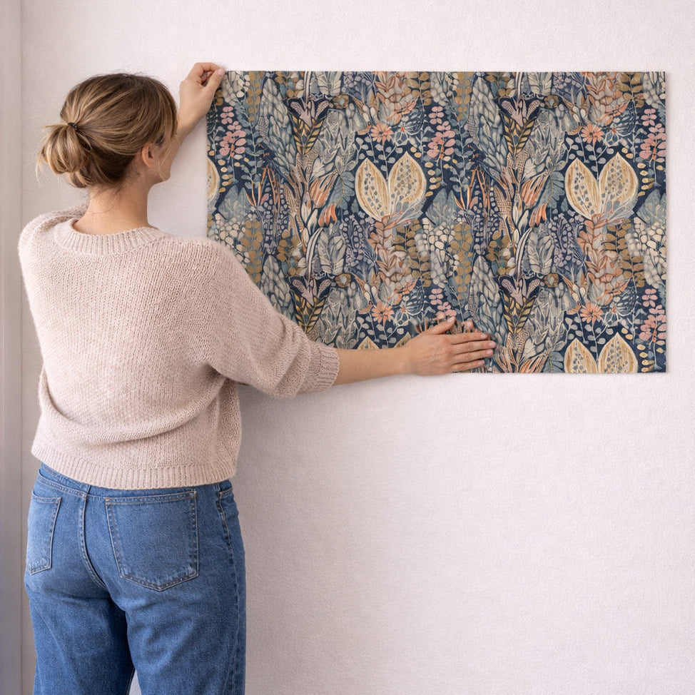 Person hanging a floral-patterned wallpaper panel on a white wall
